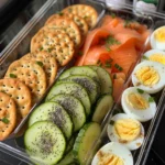 Five healthy bento snack boxes filled with various fruits, vegetables, protein, and healthy fats.